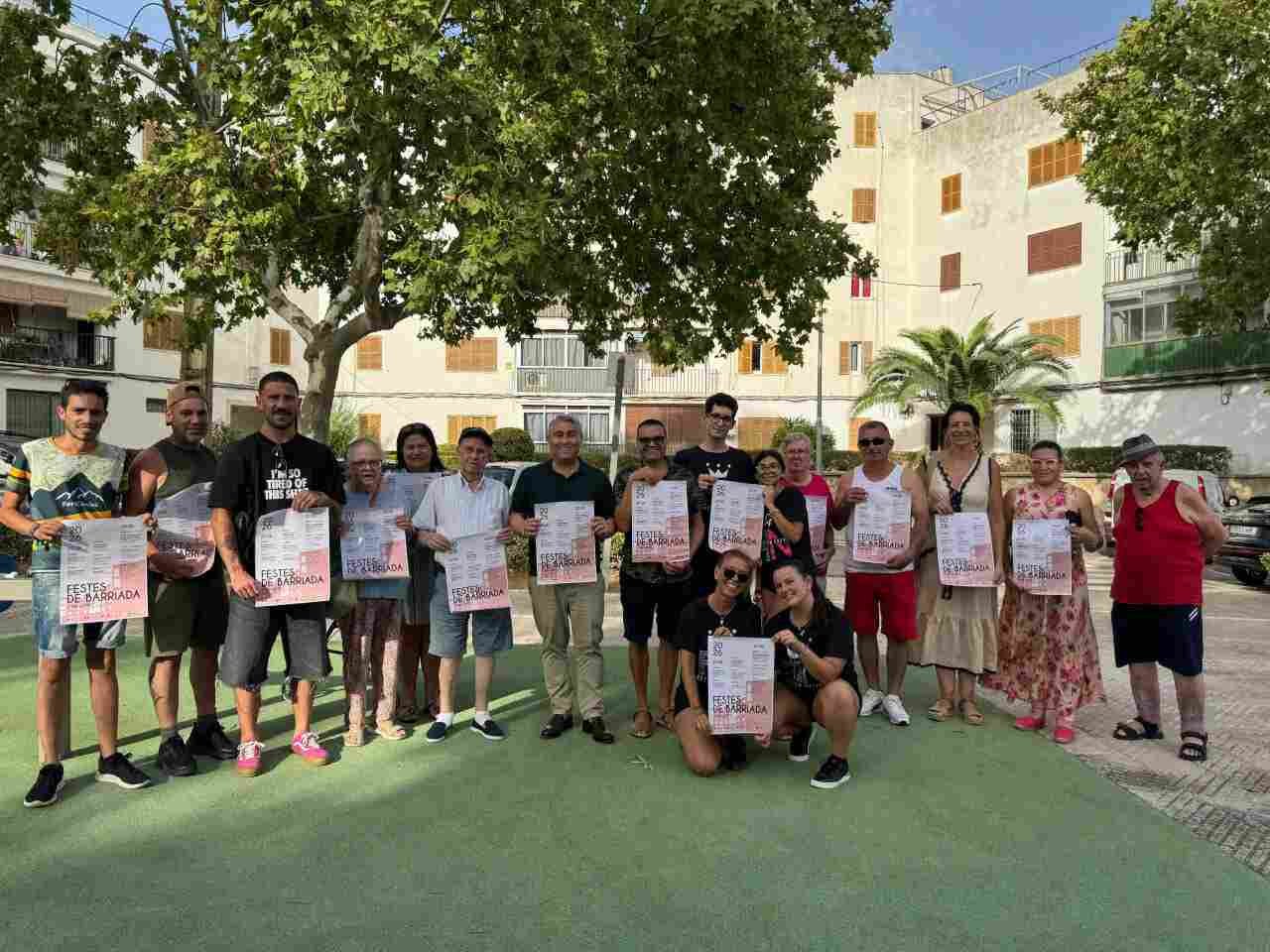 Vecinos y representantes de Can López posando con el cartel de las fiestas patronales