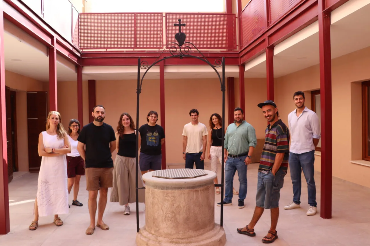 Participantes y autoridades posando junto a un pozo tradicional durante la presentación del certamen en el MUBROT