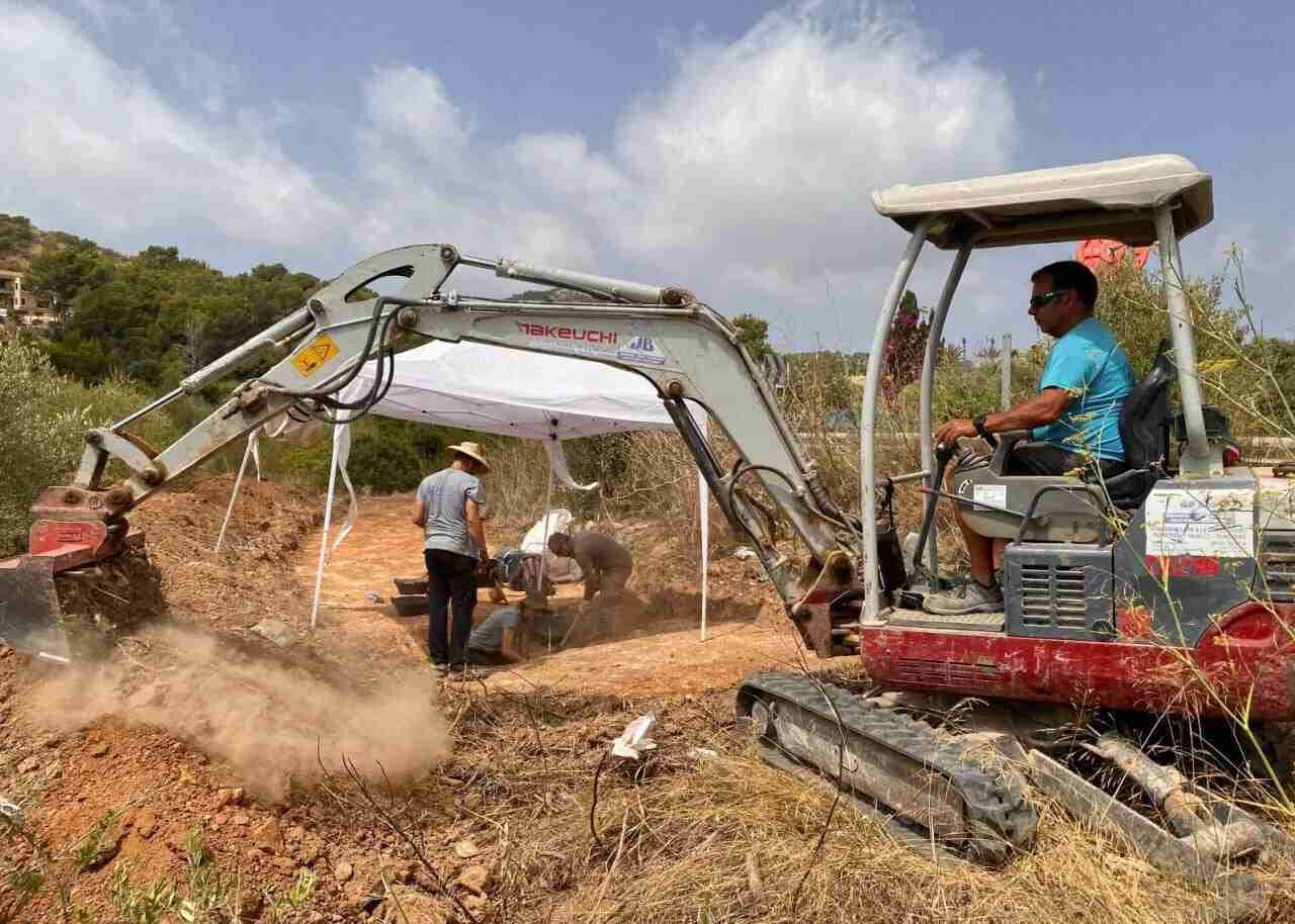 Excavadora y arqueólogos realizando trabajos de campo del V Plan de Fosas en Son Servera