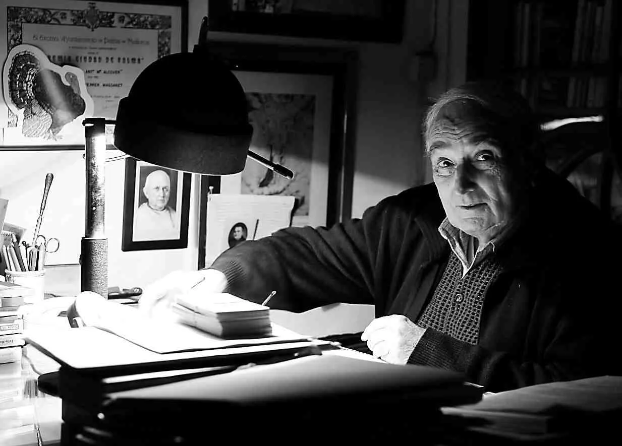 Retrato en blanco y negro del escritor e historiador Rafel Ferrer Massanet en su mesa de estudio
