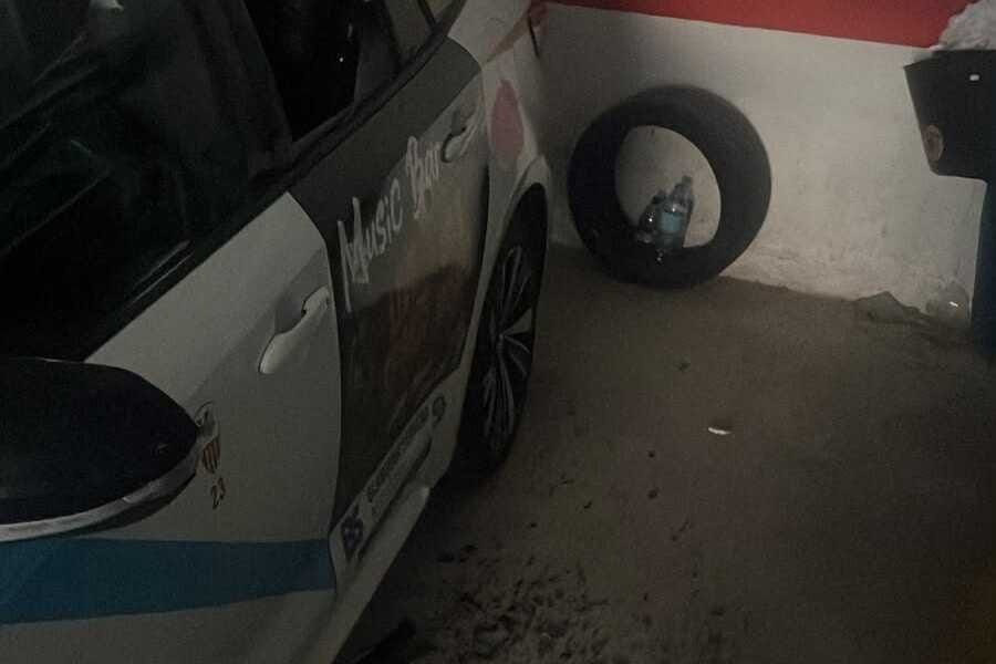 Taxi de Sant Llorenç con el cristal de la ventanilla trasera roto y restos de vidrio en el suelo de un garaje