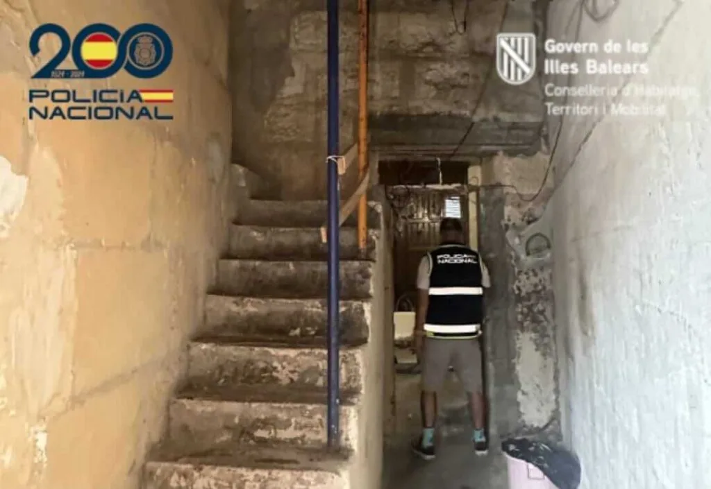 Agente de la Policía Nacional en la escalera apuntalada durante la inspección en la casa patera en Vía Majòrica