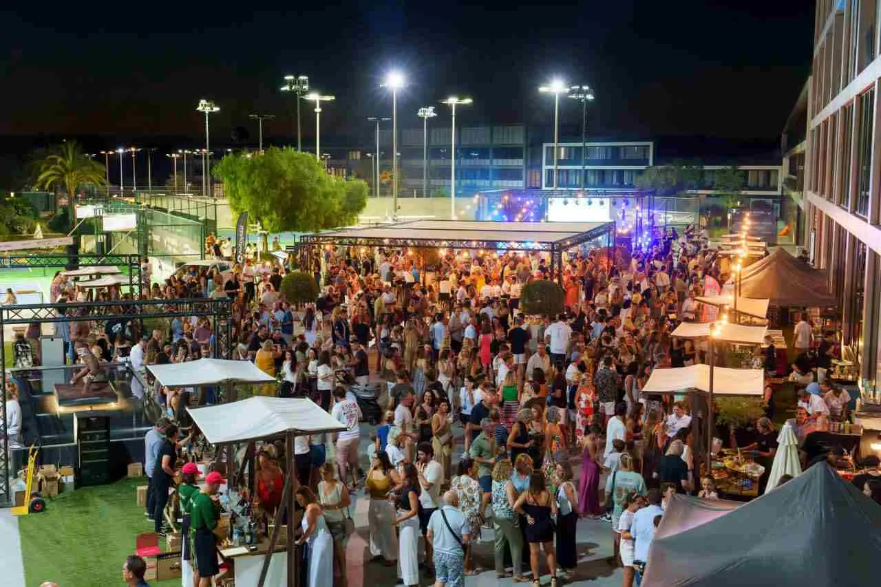 Multitud de asistentes reunidos de noche en las terrazas exteriores de la Rafa Nadal Academy durante el evento El Tie-Break