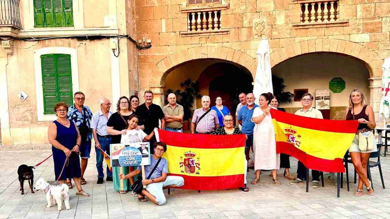 Asistentes a la concentración por Ceuta frente al Ayuntamiento de Santa Maria del Camí con banderas de España
