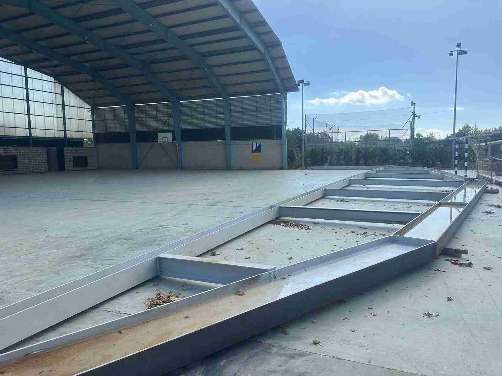 Vigas de metal apiladas frente a la estructura del polideportivo de Son Carrió durante las obras