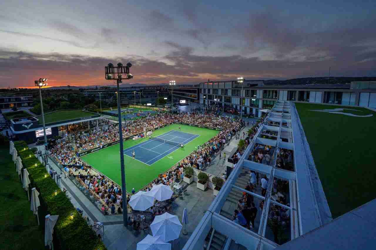Pista central de la Rafa Nadal Academy con público durante el atardecer
