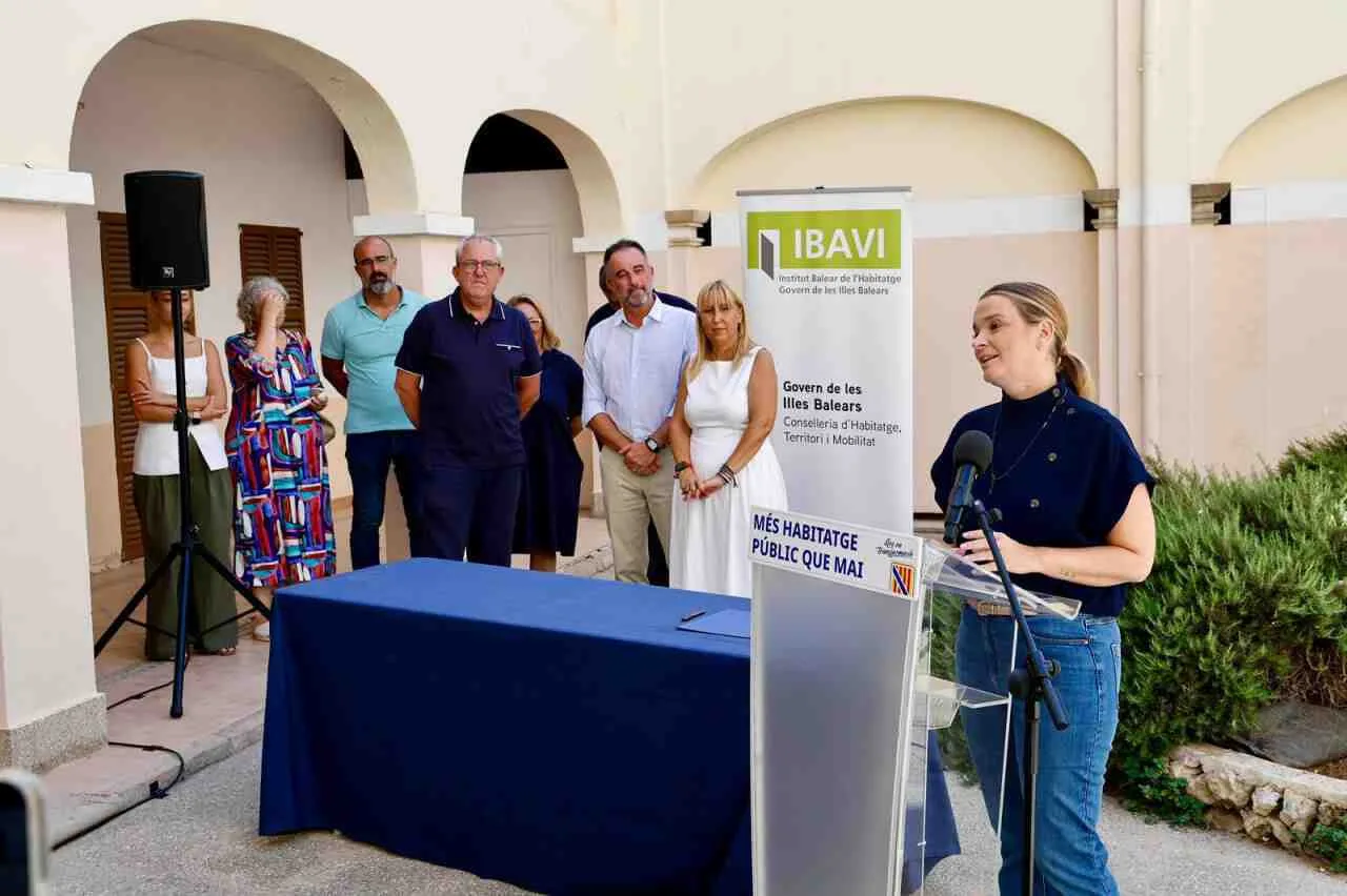 Margalida Prohens en el atril de presentación de las viviendas del IBAVI en Felanitx junto a autoridades