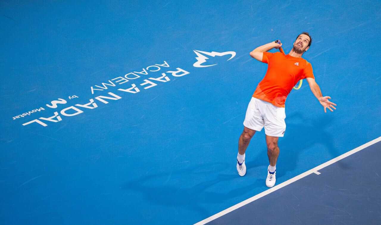 Richard Gasquet sacando en una pista azul de la Rafa Nadal Academy en Manacor