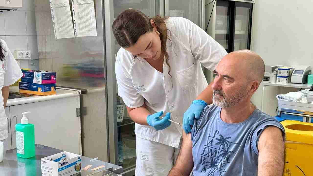 Enfermera administrando una inyección en el brazo a un paciente en un centro de salud