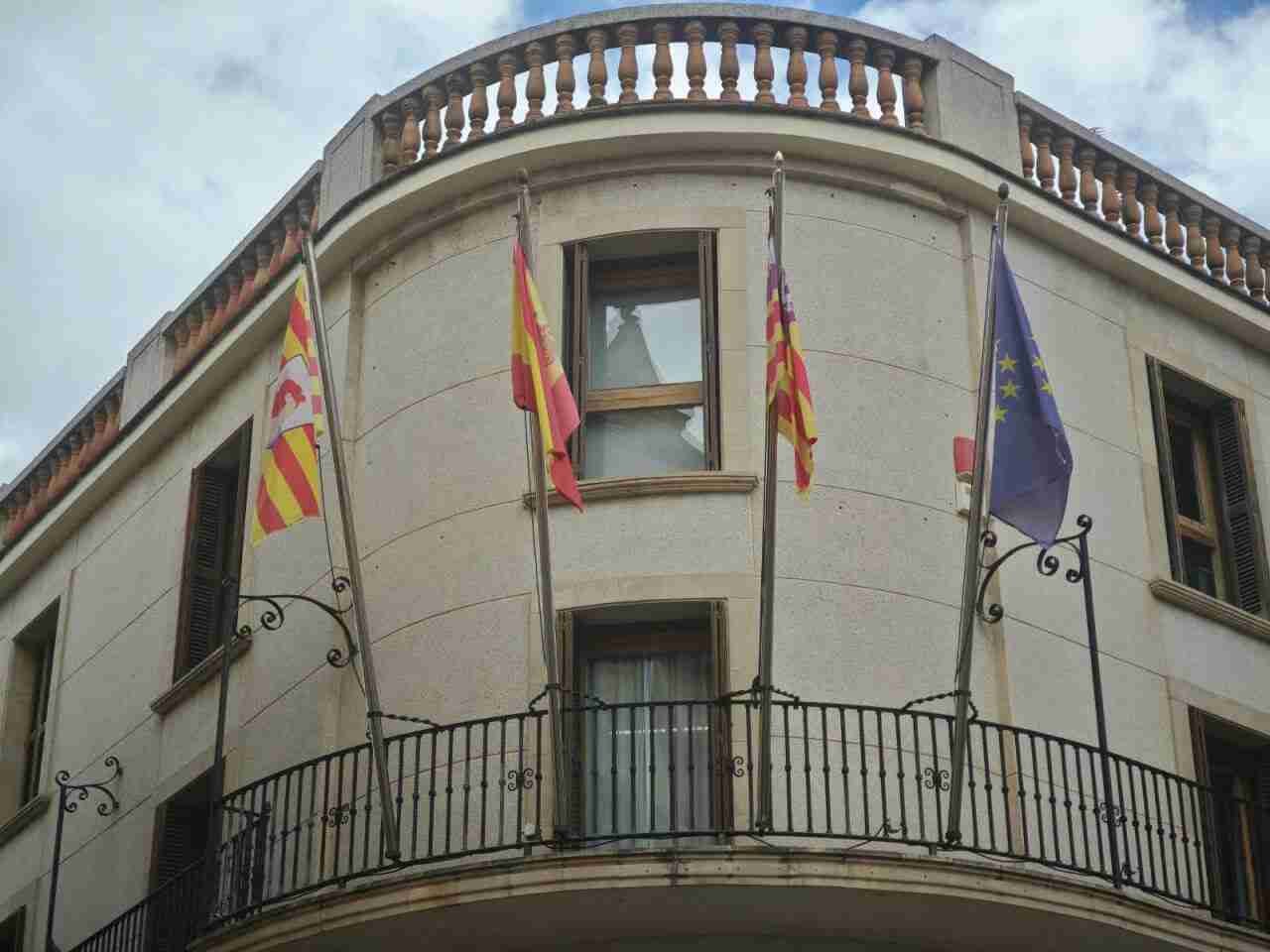 Balcón del edificio del Ayuntamiento de Manacor con las banderas oficiales ondeando