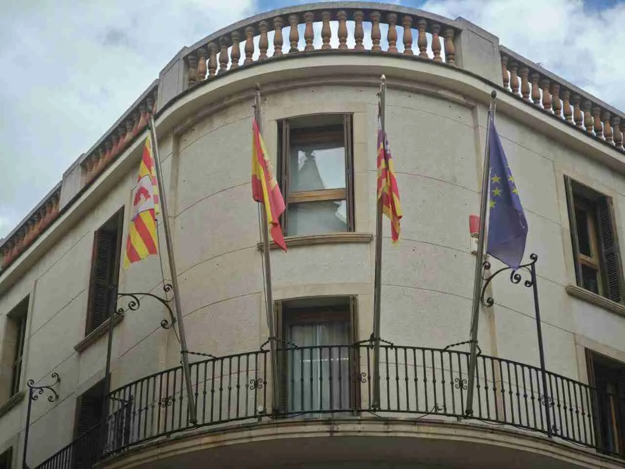 Balcón del edificio del Ayuntamiento de Manacor con las banderas oficiales ondeando