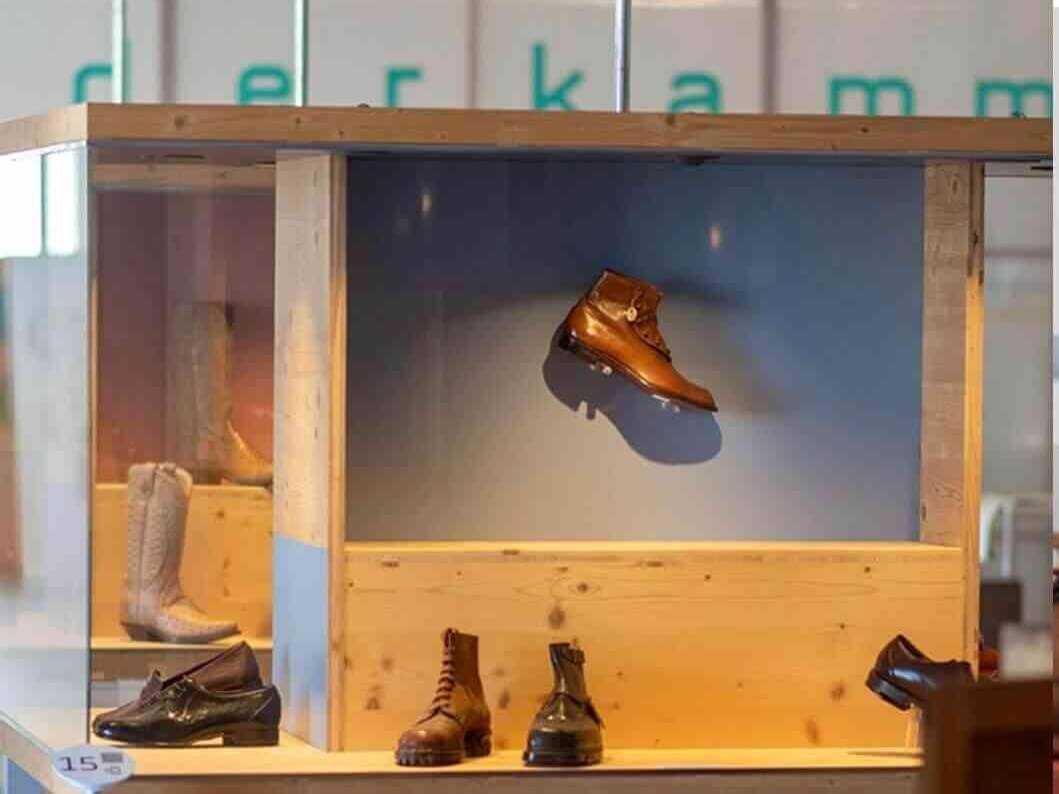 Vitrina de madera y cristal con calzado tradicional y botas expuestas en el Museo del Calzado de Inca